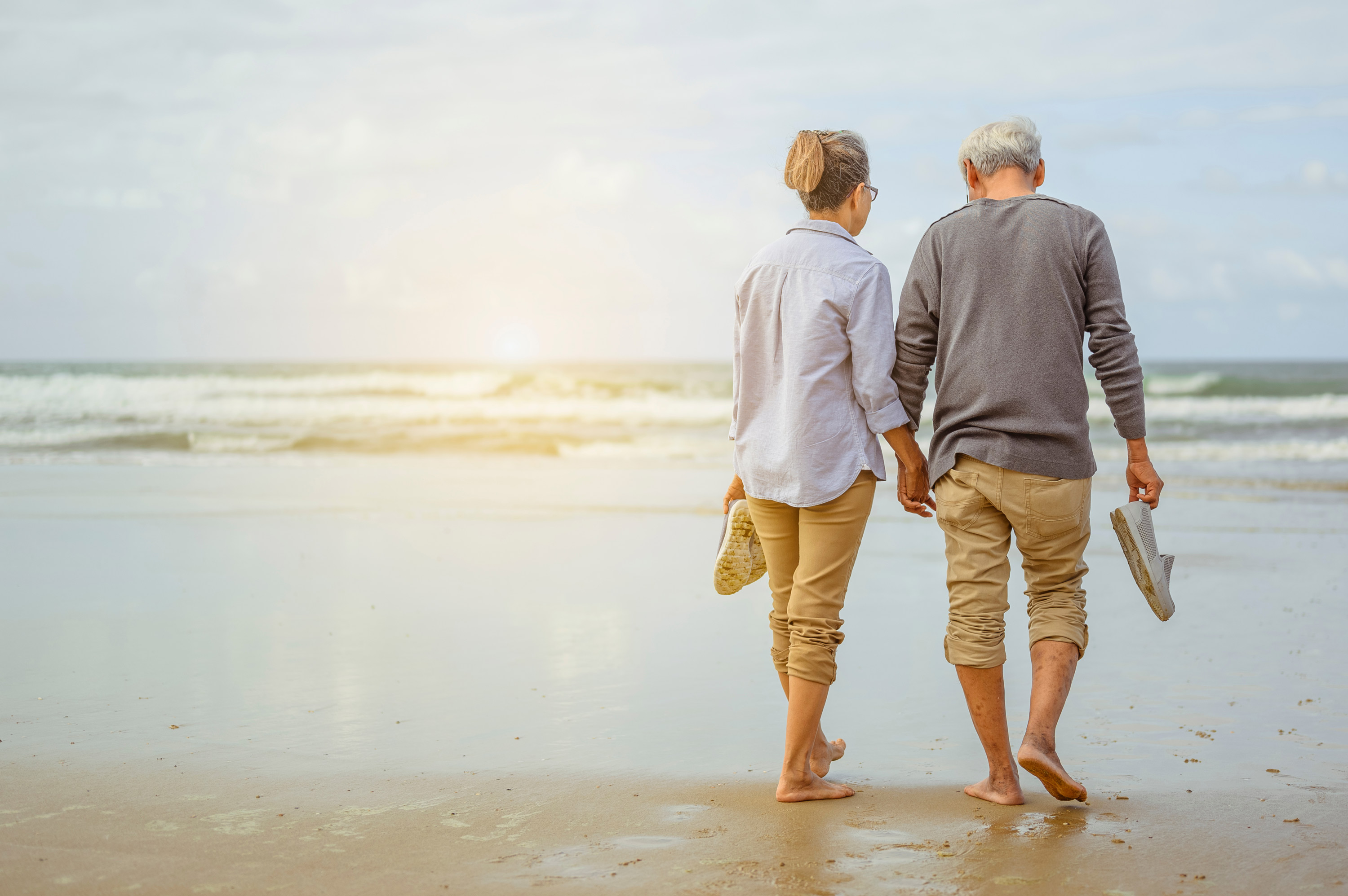 elder-couple-walking-on-beach